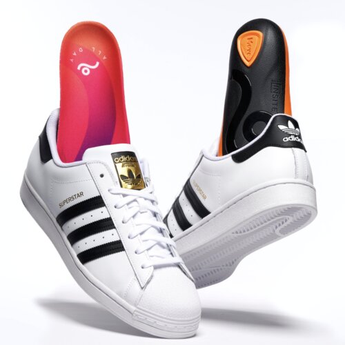 Adidas Superstar sneakers with Move Gameday insoles partially inserted. Sharp white background.
